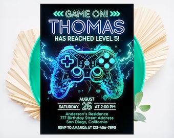 May include: A neon green and blue video game controller graphic on a black background with the text "GAME ON! THOMAS HAS REACHED LEVEL 5!" and party details for a birthday party.
