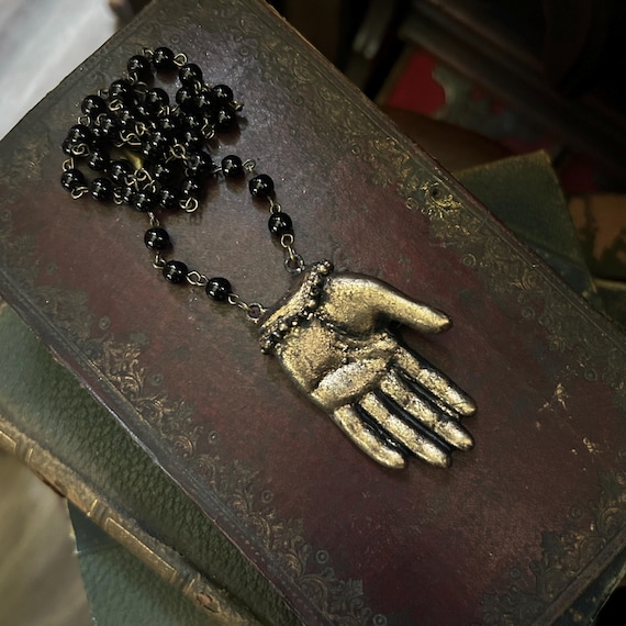 A handcrafted Hand of Glory relic-style necklace pulling straight from medieval occult iconography — the kind of wearable oddity you'd find in a curiosity cabinet, not a mall.