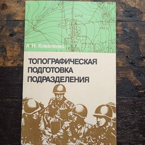 May include: A softcover book titled "ТОПОГРАФИЧЕСКАЯ ПОДГОТОВКА ПОДРАЗДЕЛЕНИЯ" by A. H. Kovalenko. The cover features a light green top section with a topographic map illustration and a cream bottom section with a brown graphic of four soldiers in helmets.