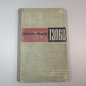 Puede incluir: Un libro vintage con una cubierta verde descolorida y un diseño rectangular rojo y negro. El título del libro, en letras blancas en negrita, dice "T360" y "TEПЛОВОЗ". La portada del libro también incluye texto en una fuente más pequeña.