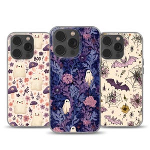 Può includere: Tre custodie per telefono con design a tema Halloween. Una custodia presenta fantasmi, funghi e la scritta "BOO!". Un'altra ha un motivo floreale con fantasmi. La terza mostra pipistrelli, ragnatele e fiori.
