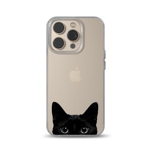 Puede incluir: Una funda transparente para teléfono con un gato negro asomando por la parte inferior. La funda está diseñada para un iPhone con la parte posterior de color dorado y un logotipo de Apple negro.