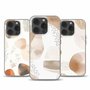 May include: Three clear phone cases with abstract watercolor designs in shades of brown, beige, and white. The cases feature a variety of shapes and patterns, including dots, lines, and swirls.