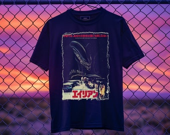 May include: A navy blue t-shirt with a vintage movie poster design featuring the alien from the movie "Alien". The poster is in Japanese and English and says "In space no one can hear you scream".