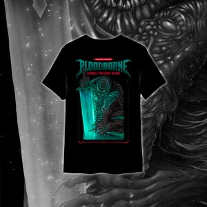 May include: Black t-shirt featuring the text "BLOODBORNE" in teal, with "LUDWIG THE HOLY BLADE" below. The graphic depicts a monster holding a glowing teal sword. The text "FROM SOFTWARE NIGHTMARE" is at the bottom.