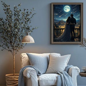 May include: A framed artwork depicts a couple gazing at a full moon over a city. The artwork is in a room with a light-colored armchair, blue pillows, and a blanket. A tree and a hanging lamp are also visible.