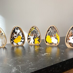 5 różnych drewnianych dekoracji na jajka wielkanocne w jednym. Wielowarstwowa ozdoba wielkanocna 3D. Króliczki, pisklęta i jajka. zdjęcie 3