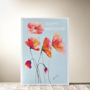 Tarjeta de "Feliz cumpleaños" con amapolas color ámbar y turquesa de Guan