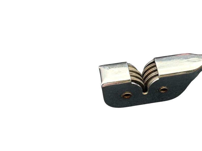 May include: A silver knife sharpener with two slots and a set of ceramic sharpening wheels.