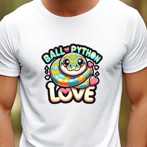 Peut inclure: T-shirt blanc avec un python royal dessiné en couleur et le texte "Ball Python Love" en rose, bleu et jaune.