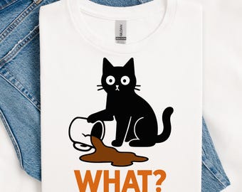 May include: White t-shirt featuring a black cat with wide eyes, seemingly having spilled a brown liquid from a container. The word "WHAT?" is printed in orange below the cat and spilled liquid.