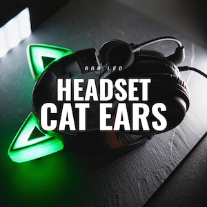 Puede incluir: Auriculares de juego negros con orejas de gato LED verdes. Los auriculares tienen un micrófono y están sobre una superficie negra. El texto "RGB LED HEADSET CAT EARS" es visible.