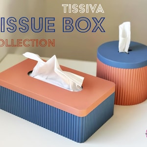 May include: Two tissue boxes, one rectangular and one round, both with a blue and orange color scheme. The boxes have a ribbed texture and are part of the "TISSIVA TISSUE BOX COLLECTION".