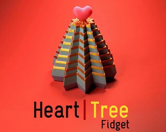 May include: A gray and gold pyramid-shaped fidget toy with a pink heart on top. The toy is labeled "Heart Tree Fidget".
