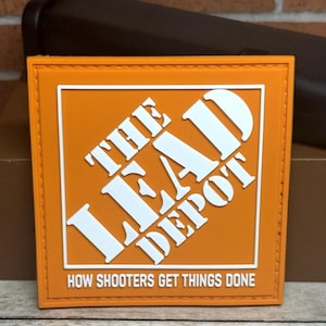 May include: Orange square patch with white text that reads "THE LEAD DEPOT" and "HOW SHOOTERS GET THINGS DONE." The patch has a Home Depot-inspired logo design.