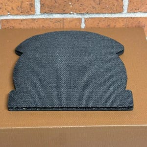 Peut inclure: Sous-verre en tissu noir de forme arrondie. Le sous-verre est fait d'un mat&eacute;riau textur&eacute; et a un bord l&eacute;g&egrave;rement sur&eacute;lev&eacute;.