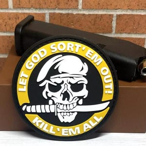 May include: A black and yellow round patch with a skull and crossbones design. The text on the patch reads "Let God Sort 'Em Out! Kill 'Em All".