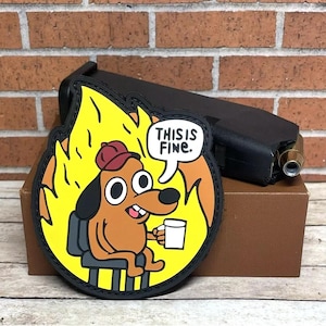 May include: A black and yellow patch with a cartoon dog sitting in a chair in a fire. The dog is wearing a red hat and holding a cup. The text "This is Fine." is in a speech bubble above the dog.