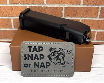 May include: A gray patch with the text "Tap Snap or Nap The Choice Is Yours" and a black and white illustration of two people in a martial arts pose.
