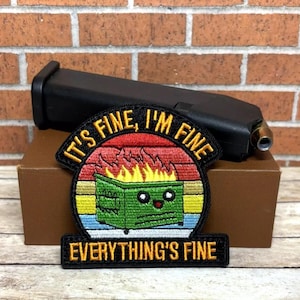 May include: A black and yellow embroidered patch with a cartoon dumpster on fire. The text on the patch reads "It's fine, I'm fine, Everything's fine."