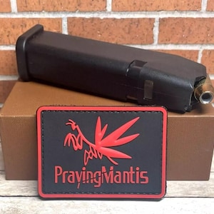 May include: Black patch with red stitching and a red praying mantis design. The text "Praying Mantis" is printed in white on the patch.