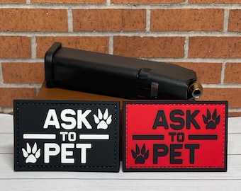 May include: Two black and red patches with white text that reads "Ask to Pet" with a paw print graphic. The patches are on a brick background.
