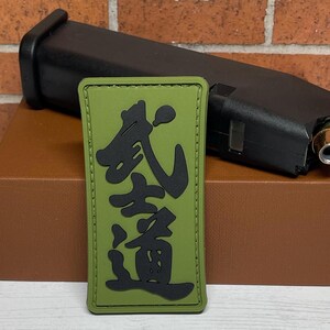 May include: Green and black patch with Japanese characters that read "武道" (Budō) which means "martial way".
