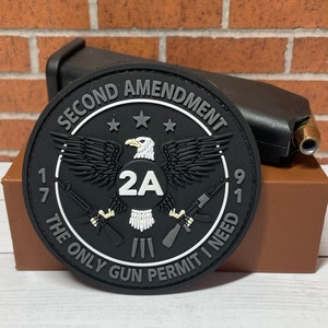 May include: Black and white patch with an eagle and two rifles. The patch reads "Second Amendment The Only Gun Permit I Need 17 2A 91".