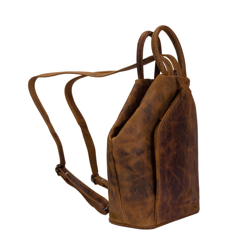 May include: A brown leather backpack with a unique design. The bag has a top handle and adjustable straps. The leather has a distressed look.