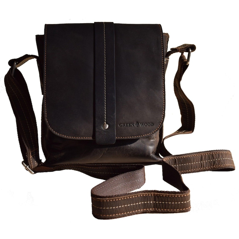May include: A brown leather messenger bag with a flap closure and an adjustable shoulder strap. The bag has a small pocket on the front with the text "GREEN WOOD" embossed on it.