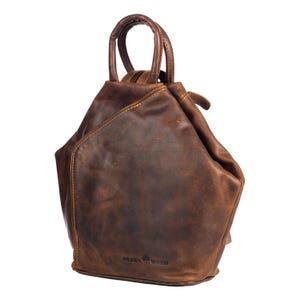 May include: A brown leather backpack with a top handle and a zip closure. The backpack has a distressed look and the brand name "GREEN WOOD" is embossed on the front.