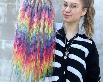 May include: Rainbow colored synthetic dreadlocks with a push-up soft base. The dreadlocks are long and wavy.