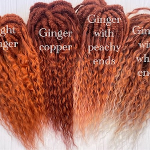 May include: Four bundles of curly hair extensions in different shades of ginger. The first bundle is a light ginger color. The second bundle is a ginger copper color. The third bundle is a ginger color with peachy ends. The fourth bundle is a ginger color with white ends.