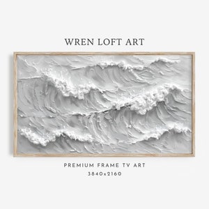 Może przedstawiać: Abstrakcyjny obraz w ramie przedstawiający białe fale na szarym tle. Obraz jest w jasnej drewnianej ramie. Tekst "WREN LOFT ART" znajduje się u góry obrazu, a tekst "PREMIUM FRAME TV ART 3840x2160" u dołu obrazu.