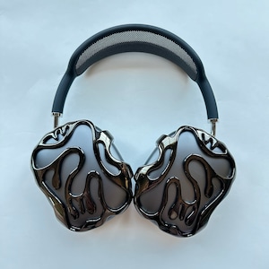 May include: Black headphones with a unique, abstract design on the earcups. The headphones have a black headband with a mesh pattern.