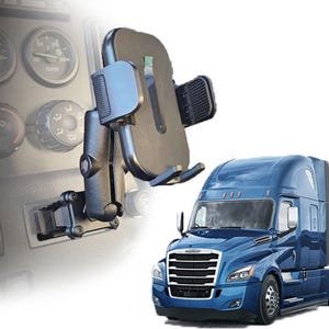 May include: A black adjustable mobile phone mount with a textured grip and a sturdy arm, attached to a vehicle dashboard panel featuring circular gauges and control knobs, positioned next to a blue semi-truck cab with a prominent front grille.