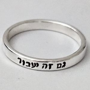 May include: A silver band ring with the Hebrew words "אם זה עבורך" engraved on the outside.