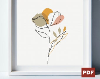 Op de afbeelding: Een ingelijst bloemenkruissteekpatroon. Het kunstwerk toont een minimalistisch ontwerp van een bloem met zwarte contouren en gevuld met gedempte kleuren goud, roze en bruin. Het PDF-pictogram staat rechtsonder.
