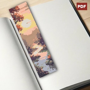 Puede incluir: Un marcapáginas de cuentas con una escena de paisaje colorida que presenta una puesta de sol, árboles y un río. El marcapáginas está hecho de pequeñas cuentas coloridas y es perfecto para agregar un toque de personalidad a cualquier libro.