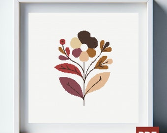 Könnte beinhalten: Ein Kreuzstichmuster mit einer stilisierten Blume mit braunen, beigen und violetten Blättern. Die Blume hat eine braune, beige und violette Mitte.