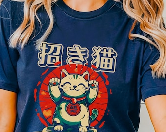 May include: A navy blue t-shirt featuring a graphic of a Japanese Maneki-Neko, or "beckoning cat", with the text "招き猫" in Japanese.