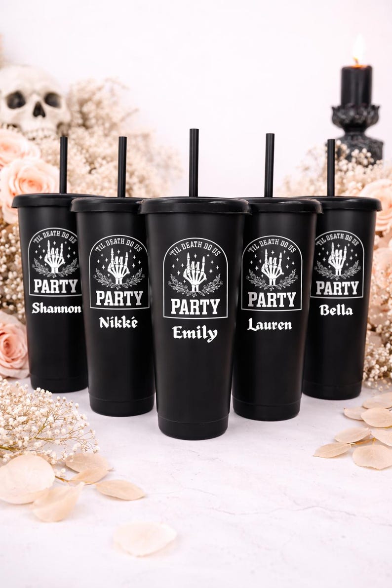 May include: Five black tumblers with lids and straws, each personalized with a name. The tumblers have a white graphic that says "TIL DEATH DO US PARTY" with a skeleton hand design. The names are Shannon, Nikk&eacute;, Emily, Lauren, and Bella.