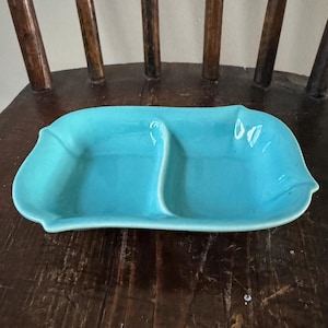 Peut inclure: Un plat de service divisé en deux parties, en céramique turquoise. Le plat a une forme unique, légèrement ondulée, et est parfait pour servir des en-cas ou des amuse-gueules.