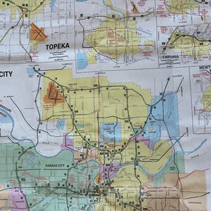May include: A detailed map of Kansas City and surrounding areas, including Topeka, Emporia, and Newton. The map features roads, highways, and city names, with a scale in miles and kilometers. The paper has a yellowed, aged appearance.