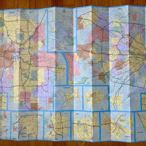 May include: Folded map of the Kansas City and St. Louis areas, featuring detailed road networks, city outlines, and geographical features. The map is divided into multiple panels with a blue border, displaying a variety of colors to represent different regions.