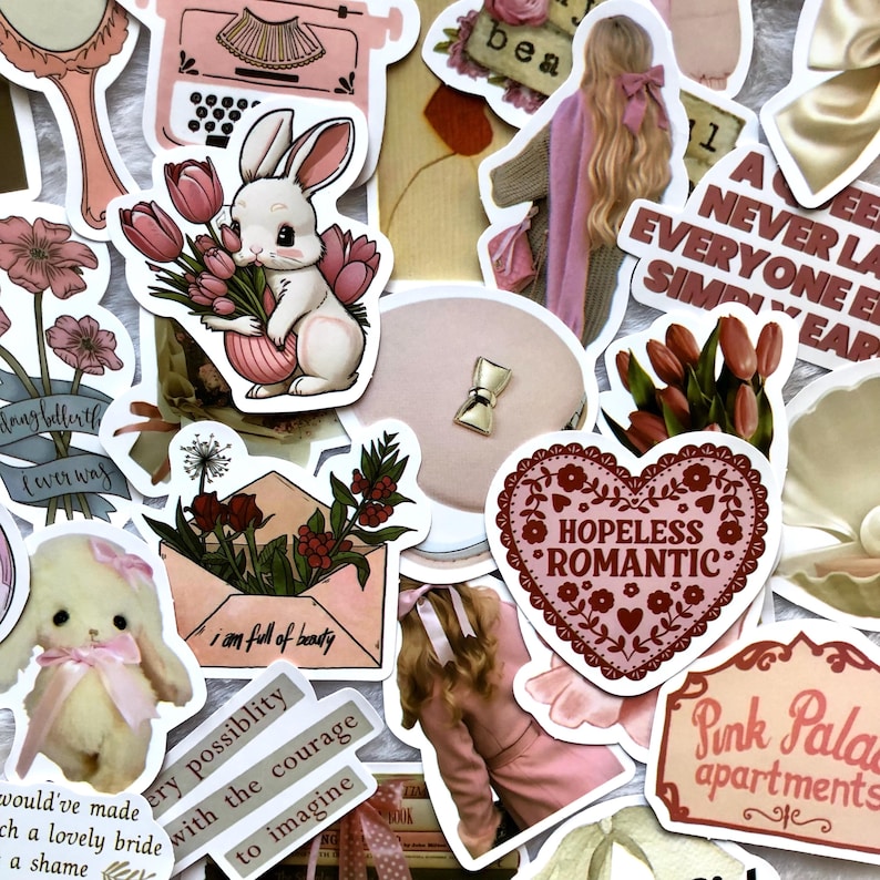 May include: A collection of pink and red aesthetic stickers featuring a bunny holding flowers, a heart with the text "Hopeless Romantic", a typewriter, a pink envelope with flowers, and a pink building with the text "Pink Palace Apartments".