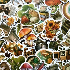 May include: A collection of colorful stickers featuring various illustrations, including mushrooms, a squirrel, a teacup, a clock, and a window. The stickers are on a white background and have a whimsical, vintage aesthetic.
