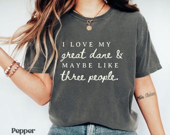 May include: Dark grey t-shirt with the text "I LOVE MY great dane & MAYBE LIKE three people." The shirt is a crew neck and has short sleeves. The word "Pepper" is at the bottom left of the image.