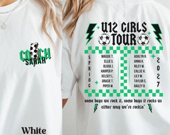 May include: A white t-shirt featuring a green and black graphic design. The front shows a lightning bolt with a soccer ball pattern and the text COACH SARAH. The back displays U12 GIRLS TOUR 2027, soccer balls, names, and the text some days we rock it, some days it rocks us either way we're rockin'.