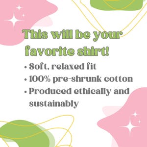 May include: A graphic design with pink and green abstract shapes and gold lines. The text reads "This will be your favorite shirt!" and lists the following features: "Soft, relaxed fit", "100% pre-shrunk cotton", "Produced ethically and sustainably".